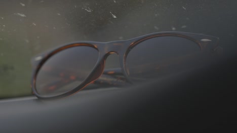 tortoise shell sunglasses wit on car dashboard