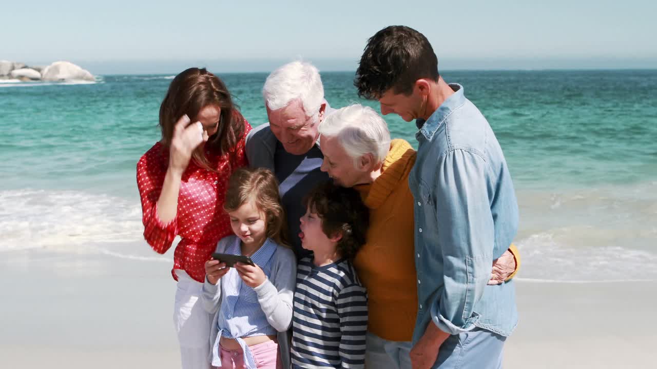 세 세대의 웃는 가족이 셀카를 찍고 있습니다.