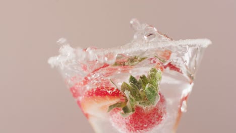 close up of drink with sugar and strawberries on white background