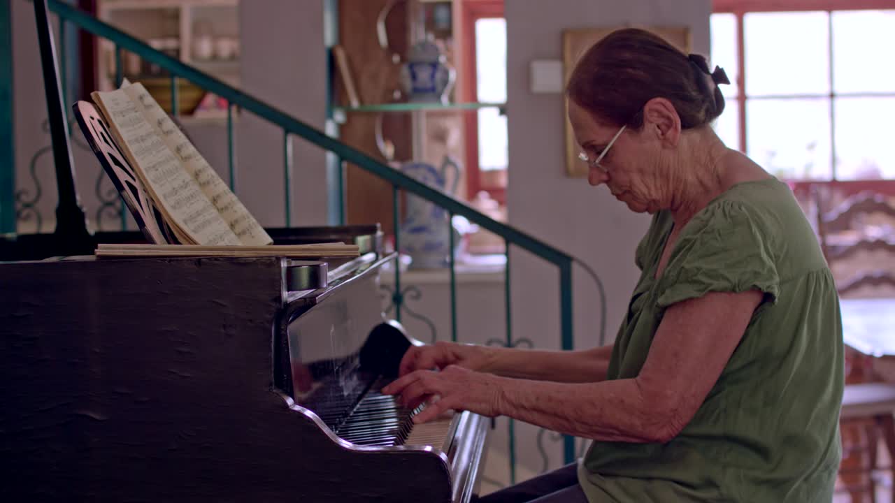 anciana tocando un piano de cola en su casa
