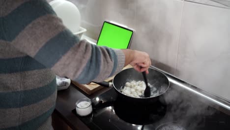 Seitenschnitt-Eines-Mannes,-Der-Sepia-Nach-Einem-Rezept-Von-Seinem-Tablet-Kocht