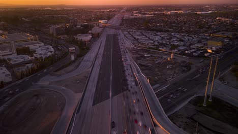 stunning drone hyper lapse captures the rush hour traffic of the 405 freeway and 39 highway in orange county, with a breathtaking sunset view over huntington beach