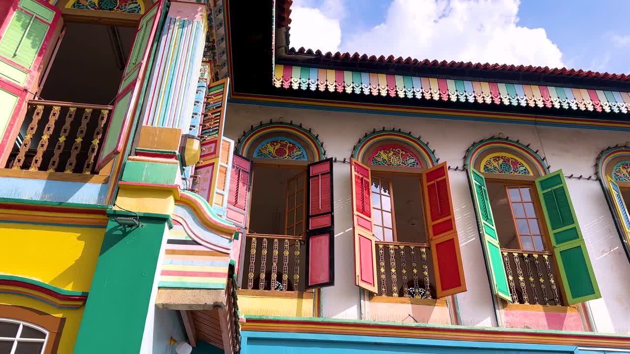 Vibrant heritage shophouse windows gradually open under bright daylight, revealing ornate details and colorful facades in a lively Singapore urban setting. Subtle upward camera movement