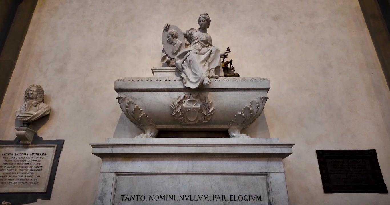 Inquadratura ascendente che evidenzia la tomba di Niccolò Machiavelli all'interno di Santa Croce a Firenze, Italia. Sculture in marmo e ornamenti raffinati riflettono l'eredità artistica rinascimentale.