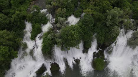 Blick-Von-Oben-Auf-Den-Wasserfluss-Durch-Bäume-Am-Kravica-Wasserfall-In-Bosnien,-Schöner-Ort-Für-Naturtourismus