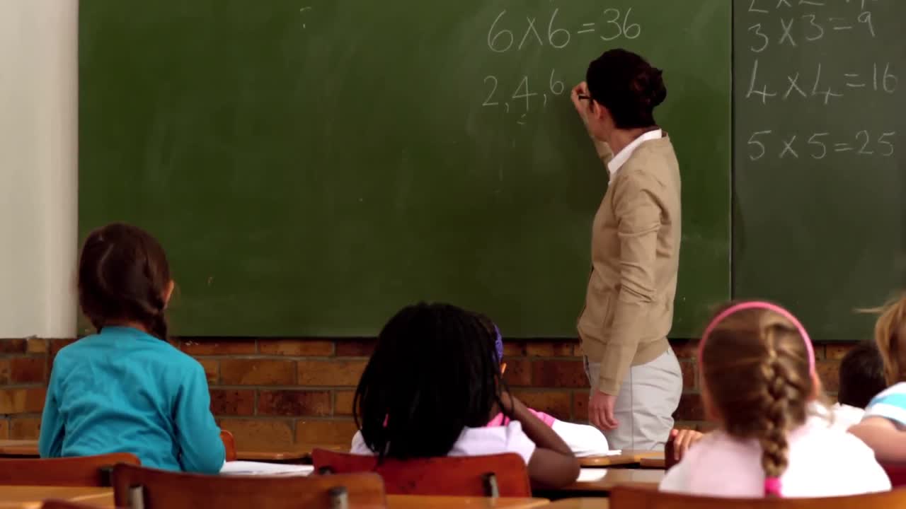 maestra enseñando matemáticas a sus alumnos jóvenes en el aula