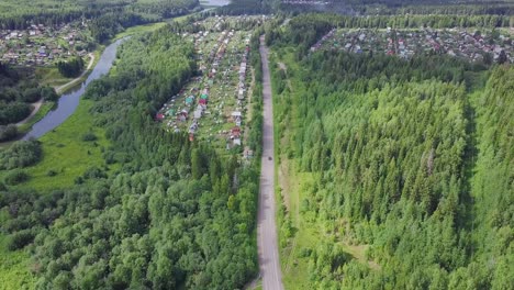 aerial view of a country road through a forest and village