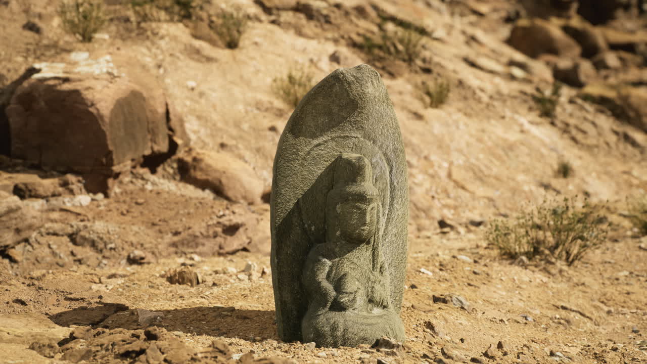 Ancient stone sculpture of deity discovered in arid landscape near ruins