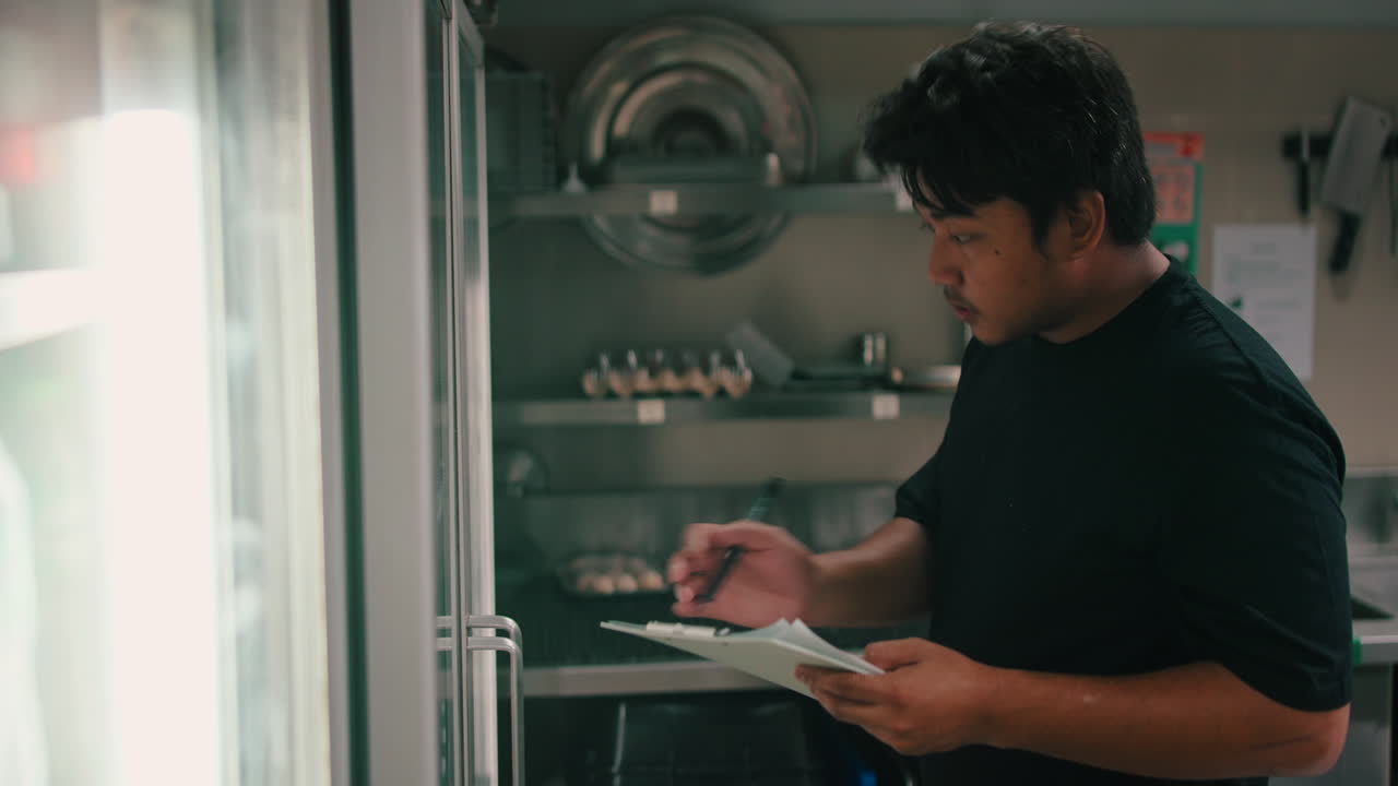 Man Checking Inventory in Restaurant Kitchen