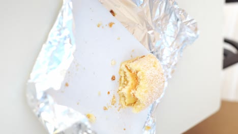 mano de mujer casada tomando dulces de papel de aluminio, vista vertical de cerca