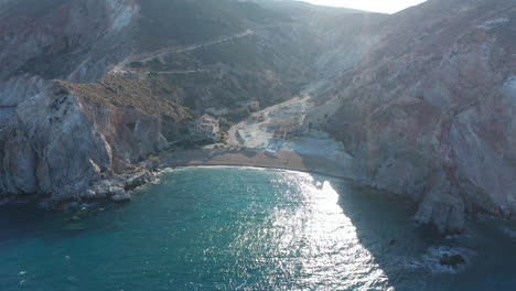 Wide-Aerial-Establishing-Dolly-Flight-into-Tropical-Paradise-Bay-with-Turquoise-Water-on-Greek-Island-at-Golden-Hour