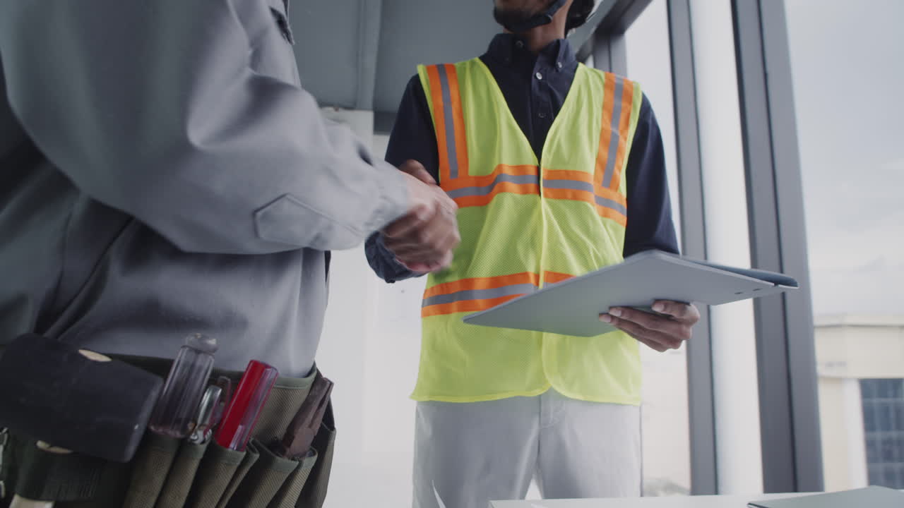 Foreman Giving Handshake to Male Contractor after Deal on Construction Site