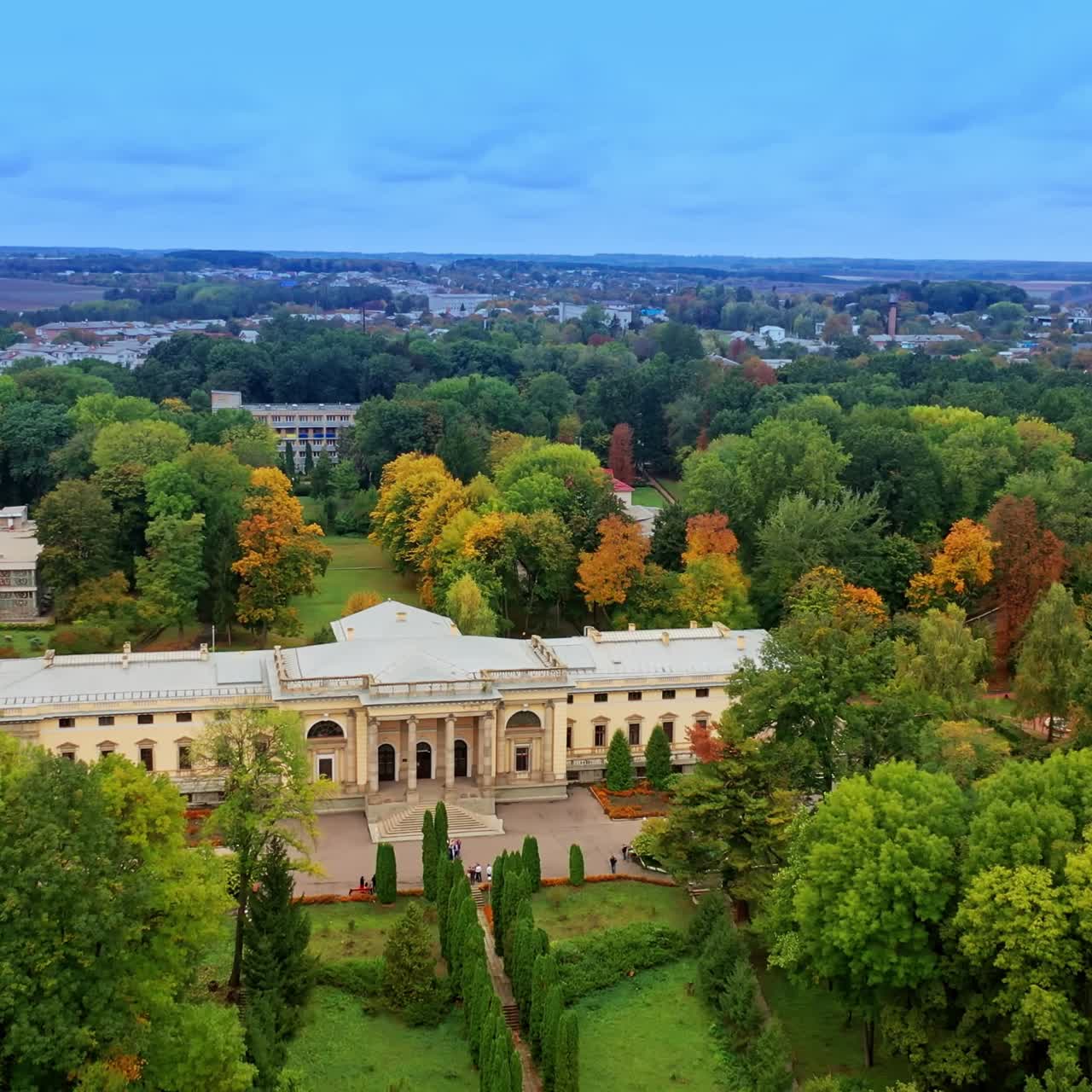 Rising over the green park with amazing palace locating in the middle. Cityscape and farmlands at backdrop