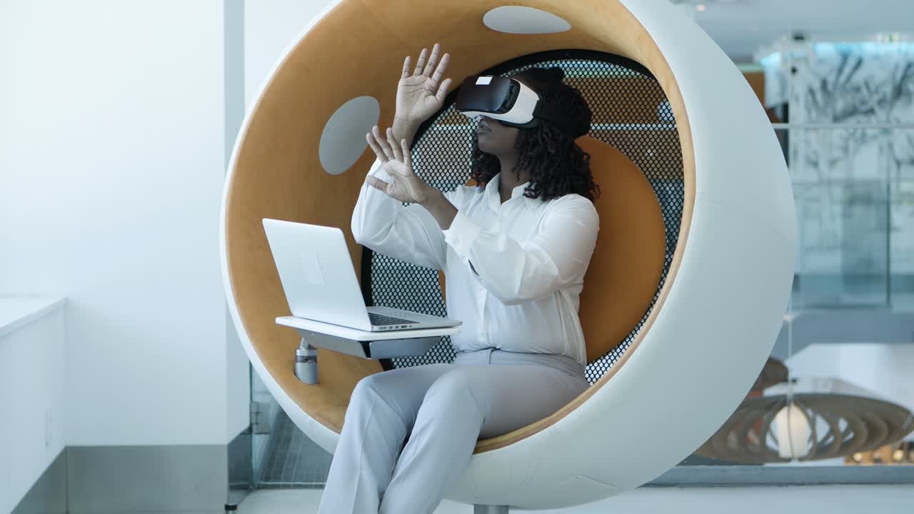 Focused young businesswoman with laptop and vr headset