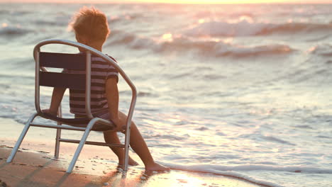 Junge-Sitzt-Allein-Auf-Dem-Stuhl-Am-Meer