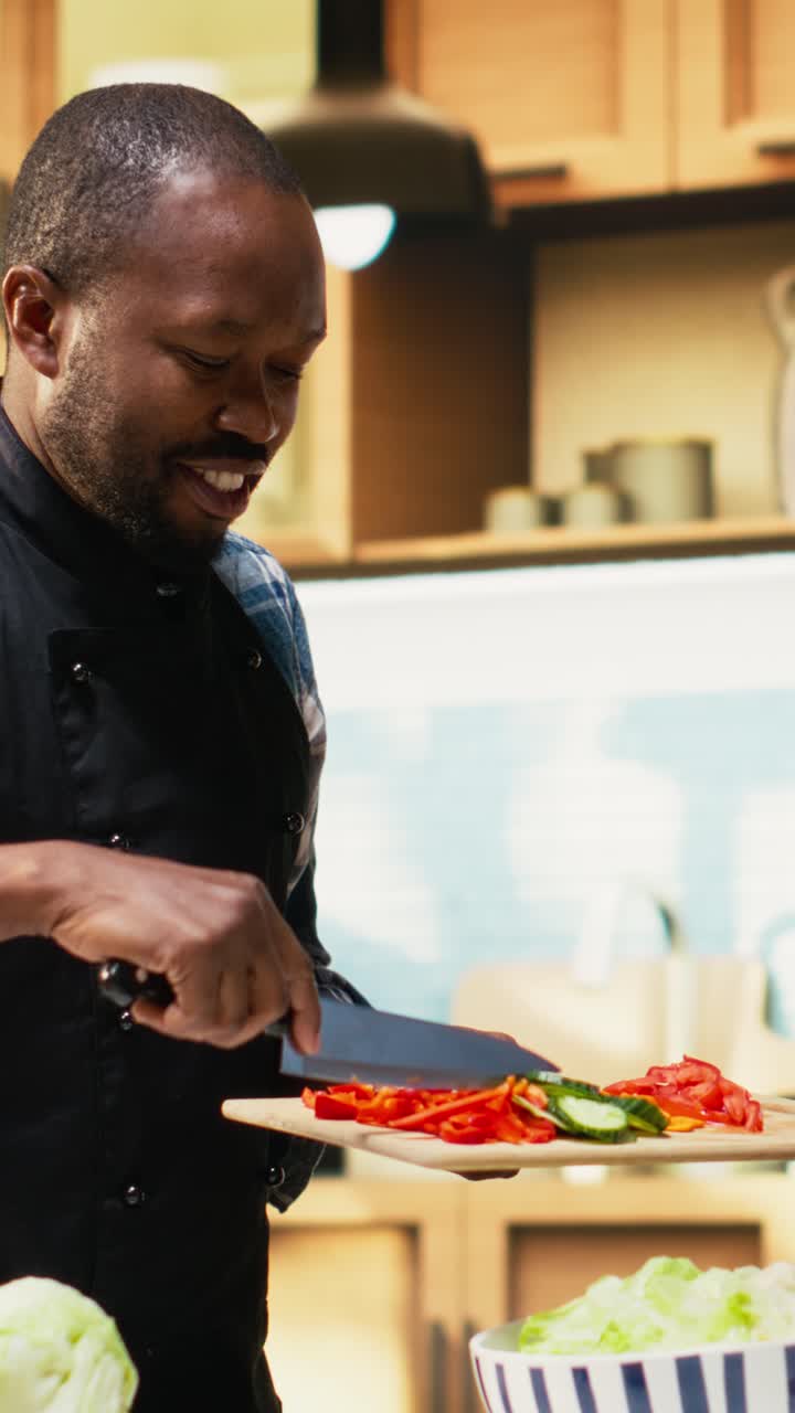 Vertical Video African american guy adding chopped vegetables from the cutting board