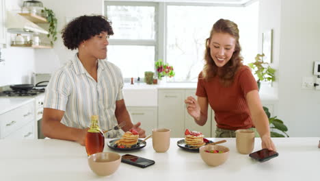 diverse couple enjoying breakfast together at home, sharing pancakes and conversation
