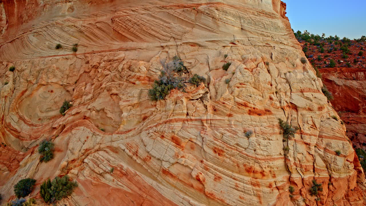 Drone footage soaring above captivating rock structures along the red rock canyon wall.