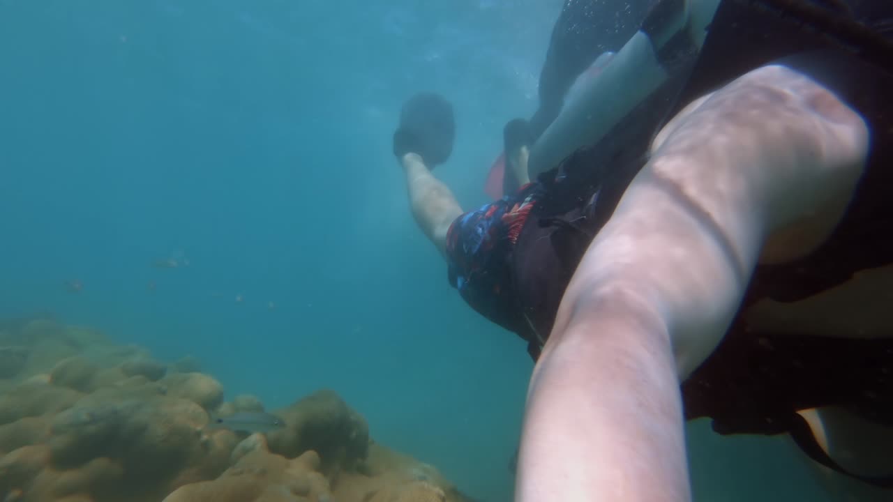 브라질 리오 그란데 도 노르테에 있는 마라카자우의 맑고 푸른 물을 헤엄치며 고프로를 들고 휴가 스쿠버 다이빙을 하는 관광객