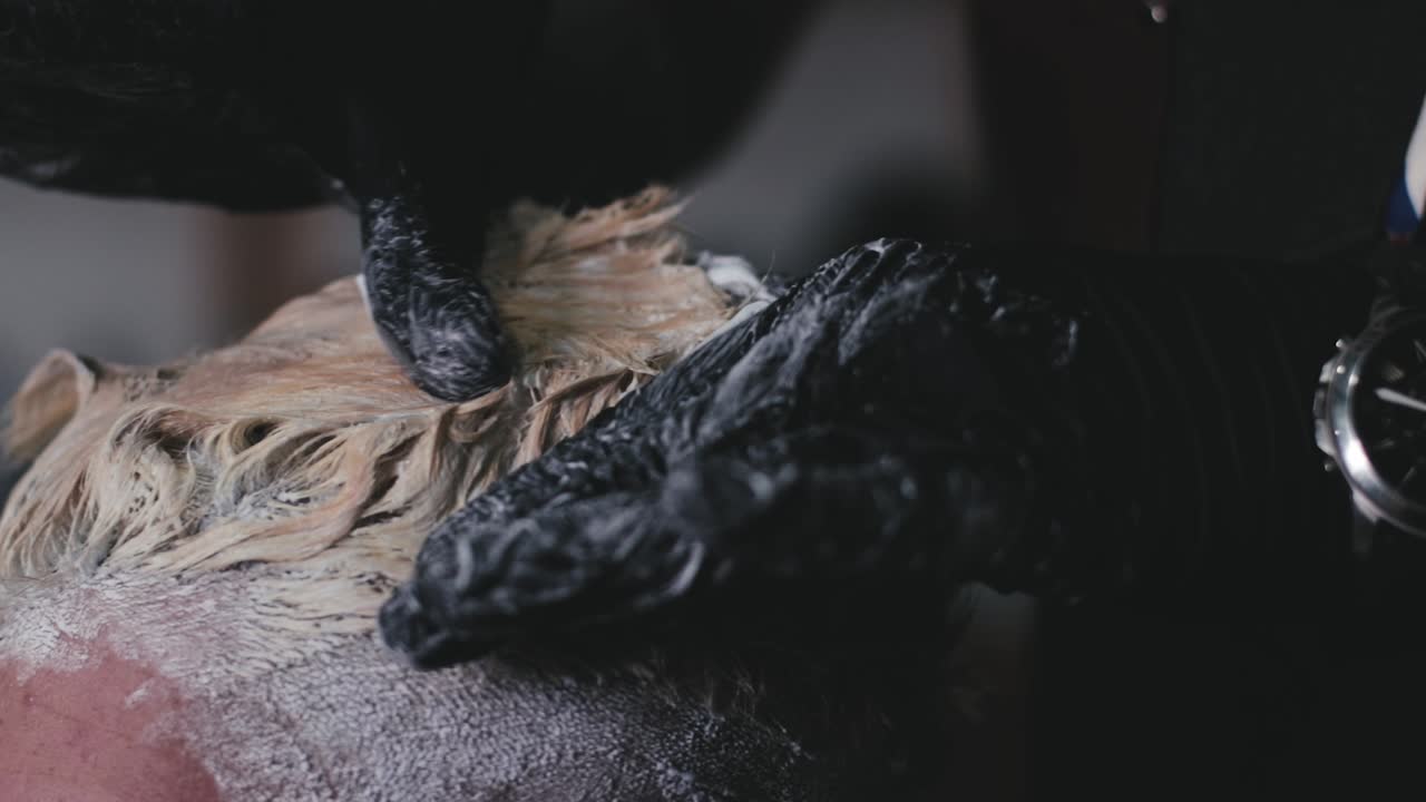 머리를 금발로 염색하고 손으로 염료를 혼합하는 전문 미용사