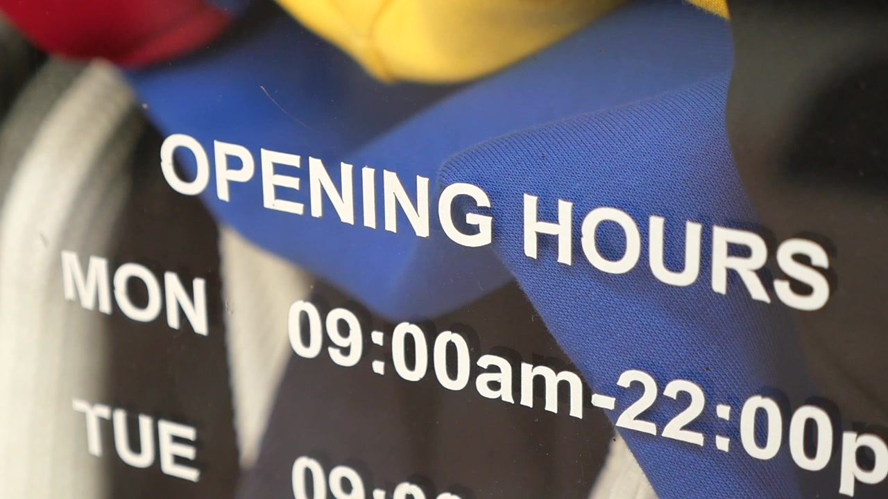 Store Opening Hours Sign on Glass Window
