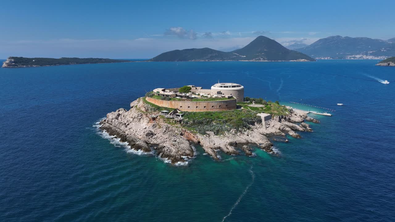 Aerial pullback of Mamula Island and surrounding Adriatic Sea on a sunny clear day in Montenegro