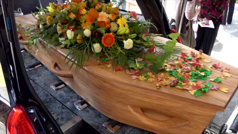 closeup shot of a funeral casket in a hearse or chapel or burial at cemetery