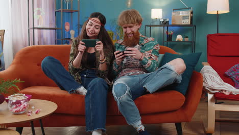 happy family married couple man woman playing shooter video app games online on smartphone at home