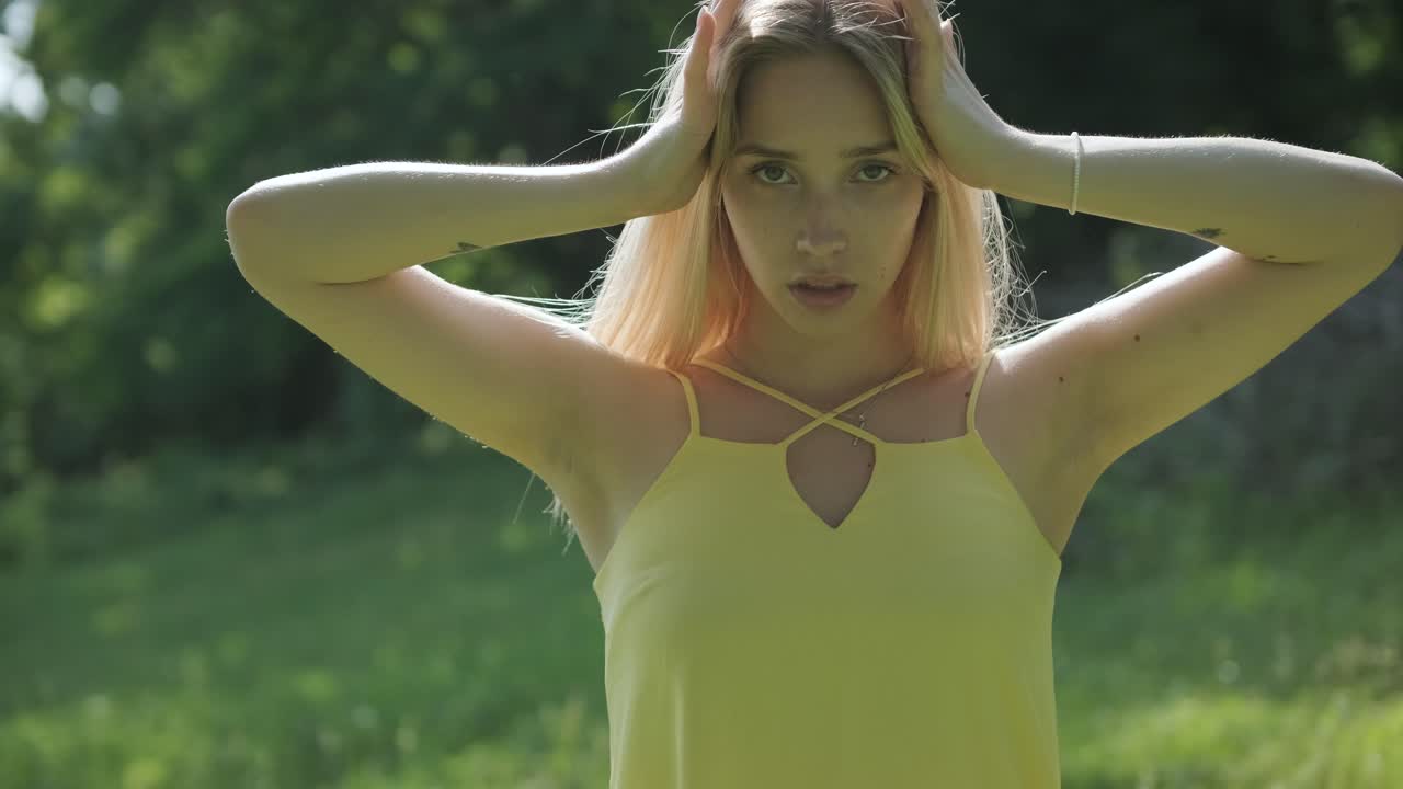 mujer con vestido amarillo bailando con gracia en el parque de verano