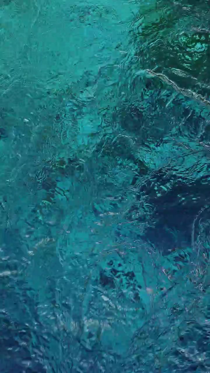 Superficie dell'acqua turchese increspata in una piscina