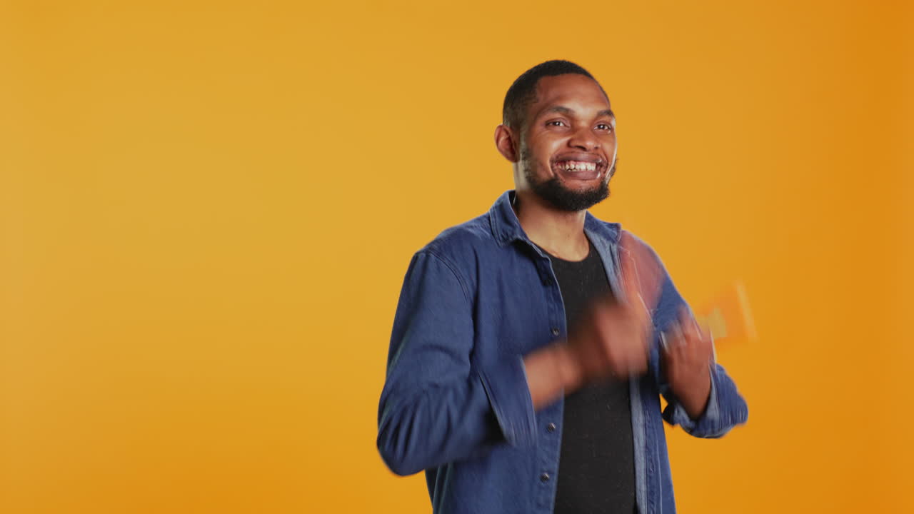 Cheerful guy mimics playing drums with two carrots in studio