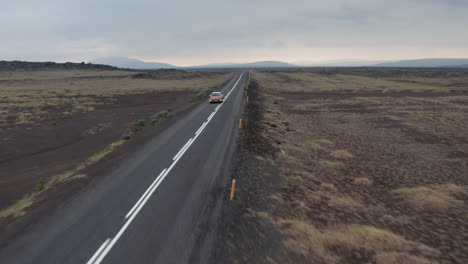 Aerial-view-car-driving-along-the-most-important-highway-of-Iceland,-the-Ring-Road-that-runs-all-around-island.-Drone-view-car-exploring-wilderness-icelandic-highlands.-Freedom-concept