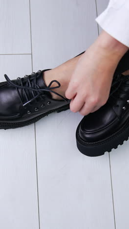woman trying on black platform oxford shoes