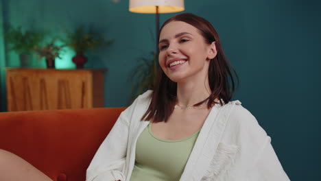 feliz mujer joven tranquila sonriendo mirando hacia otro lado soñando descansando, buenas noticias, sentirse satisfecha en casa