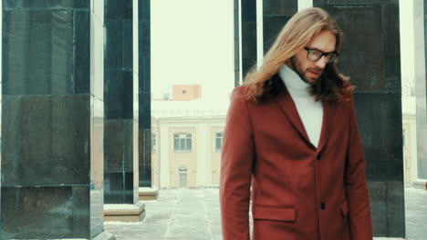 atractivo hombre hipster barbudo en abrigo de moda rojo