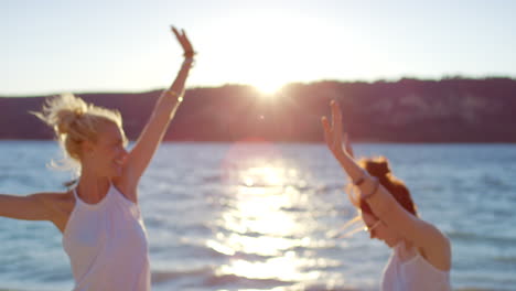 happy friends at sunset beach