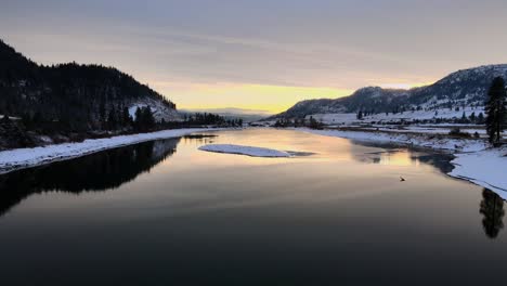 thompson river during sunset in winter month, mountains surrounding kamloops british columbia , drone shot