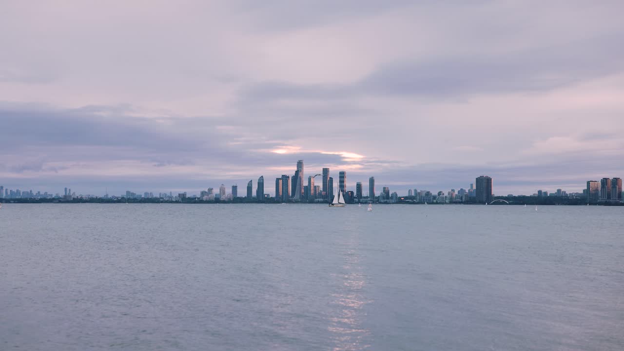 온타리오 토론토 일몰 시 호수 건너편에 고층 건물이 밀집된 도심의 해안가 스카이라인 전망