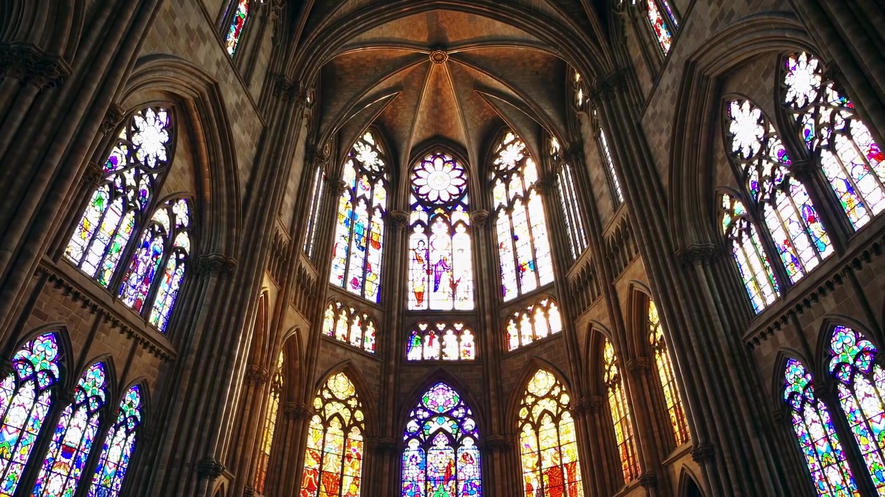Luz solar que se filtra a través de vidrieras en una catedral gótica