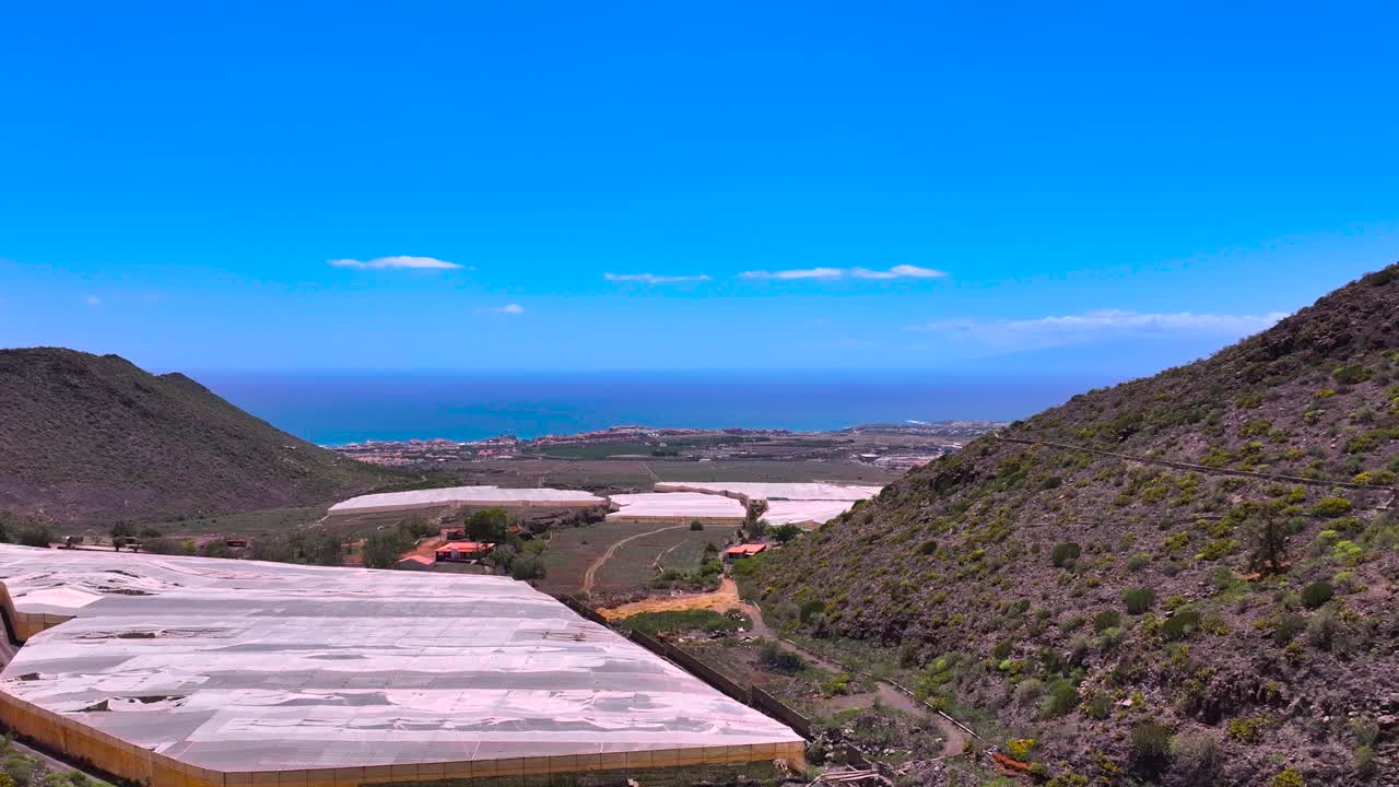 Volcanic hills and banana plantations near Costa Adeje, with ocean in background