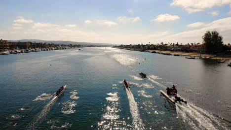 Rowing-crew-regatta-race-with-three-8-man-boats-approaching-finish-line-in-Newport-Beach,-California-harbor