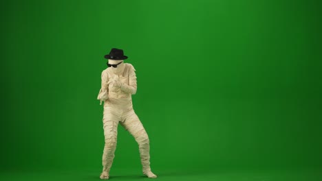 scary mummy wrapped in bandages dances wearing a black hat and sunglasses green screen isolated scary mummy wrapped in bandages dances wearing a black hat and sunglasses green screen chroma key mock up workspace for your promotion clip or advertisement medium size halloween holidays