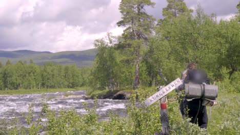 hikers walking next to a big river along the kings path in sweden