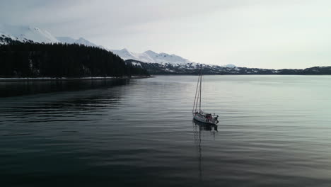 aerial view around a sailboat moored in calm waters of zaikol bay, alaska