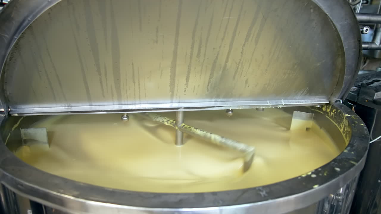 Butter production. Automated equipment mixing dairy product for making butter. Process of making fresh butter on a milk farm. Close-up.