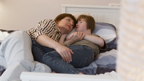 young girl talking with her mother on the bed