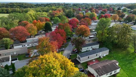 Vista-Aérea-De-Un-Parque-De-Casas-Móviles-Con-Coloridos-árboles-Otoñales-Y-Campos-Verdes