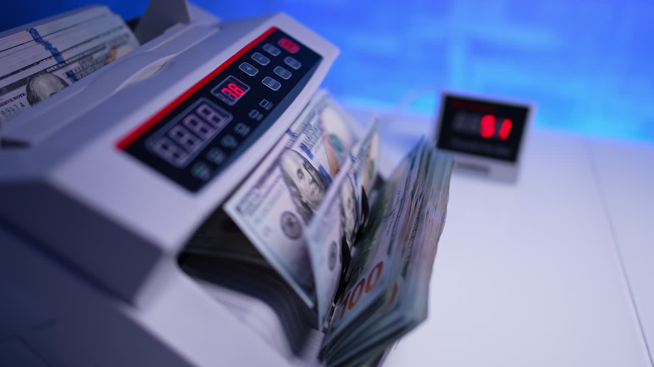 Modern automatic cash counting machine. One hundred dollar bills stack is put inside for calculation. Close up.