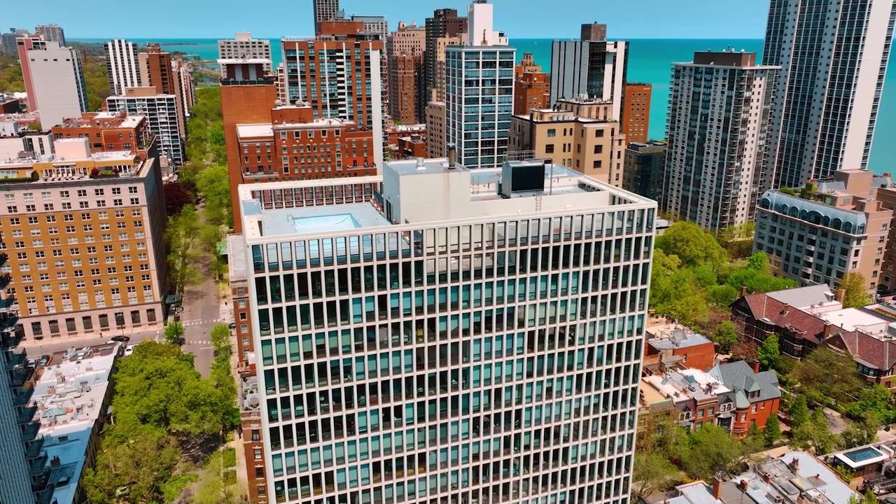 Aproximando-se de um edifício de escritórios de vários andares perto da costa de Chicago, Illinois, EUA. Arquitetura de arranha-céus ao redor. Vista aérea