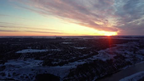 drone footage of calgary's real estate during a beautiful winter sunrise with god rays